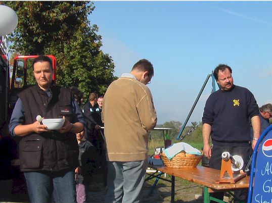 Besucher mit Suppenschüssel vor dem Grillstand